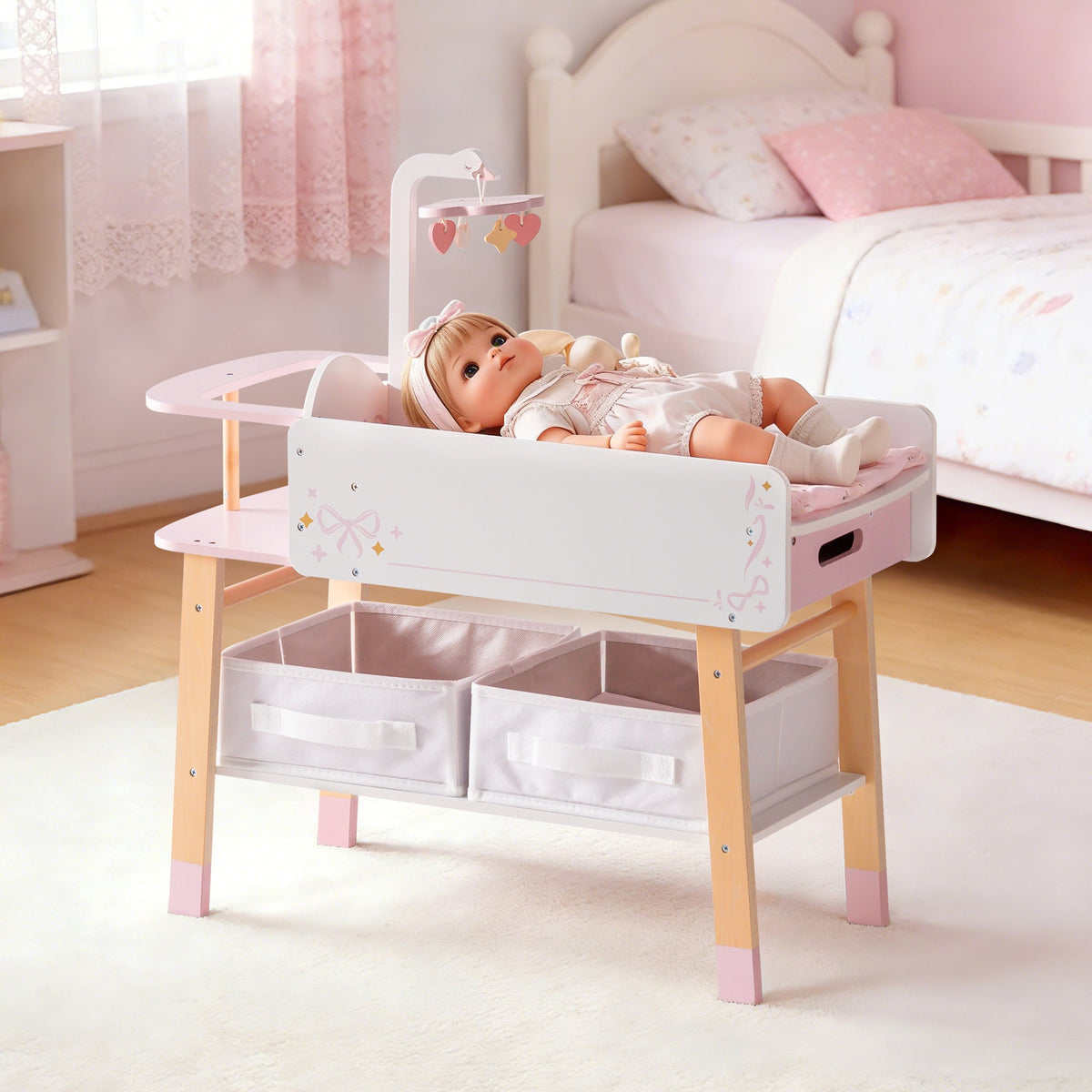 ROBUD wooden doll changing table in pink and white, shown alone in a cozy bedroom setting with storage baskets.