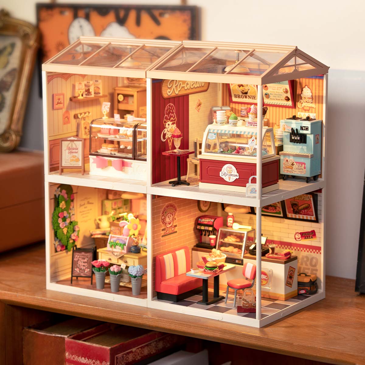 Rolife Super Creator 4-in-1 Four Grid miniature house angled view displaying an ice cream shop, fresh flower boutique, bubble tea bar and diner with pink decor