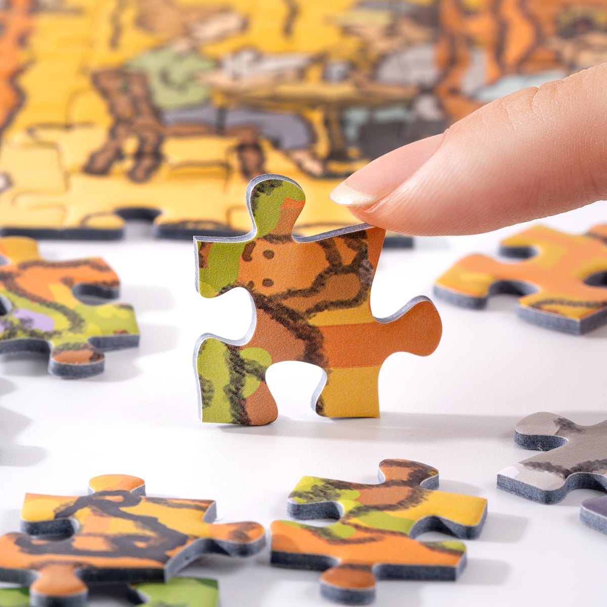 Hand lifting a Rolife Pub in London PT007 puzzle piece showing warm orange pub exterior tones from the spread puzzle