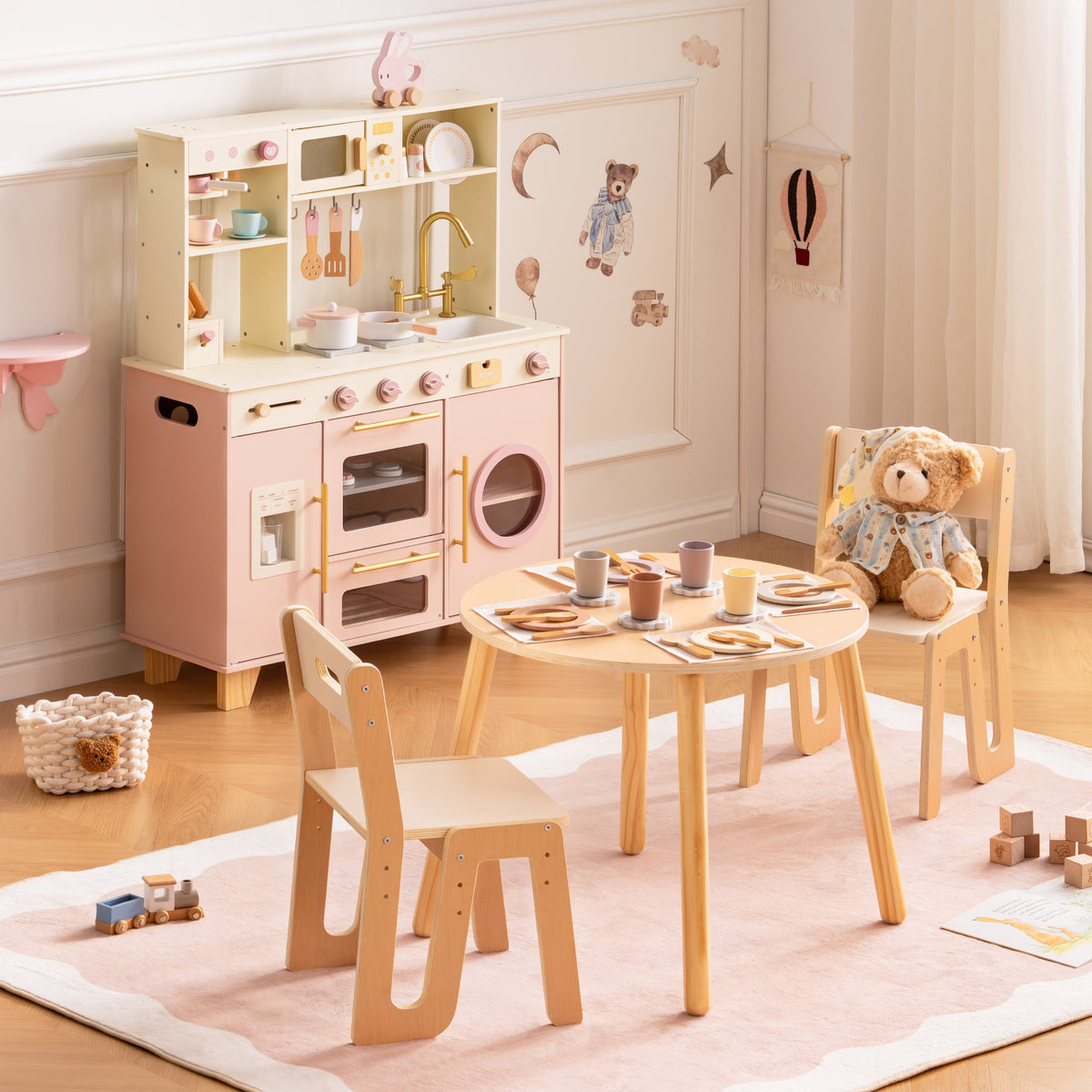 ROBUD Glowwood full kitchen play set with table, chairs, pink kitchen unit, and wooden toy food arranged in a bright room.