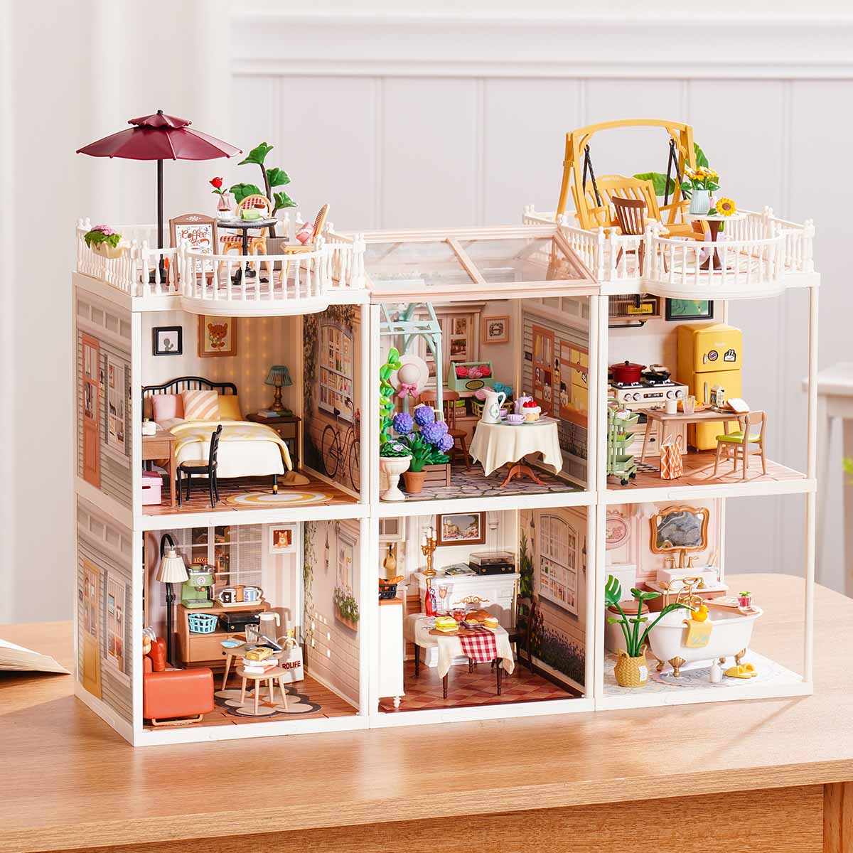 Rolife Super Creator Series 6-in-1 Six Grid horizontal miniature combining six rooms including bedroom, garden tea room, kitchen, living room, dining room, and bathroom with umbrella rooftop.