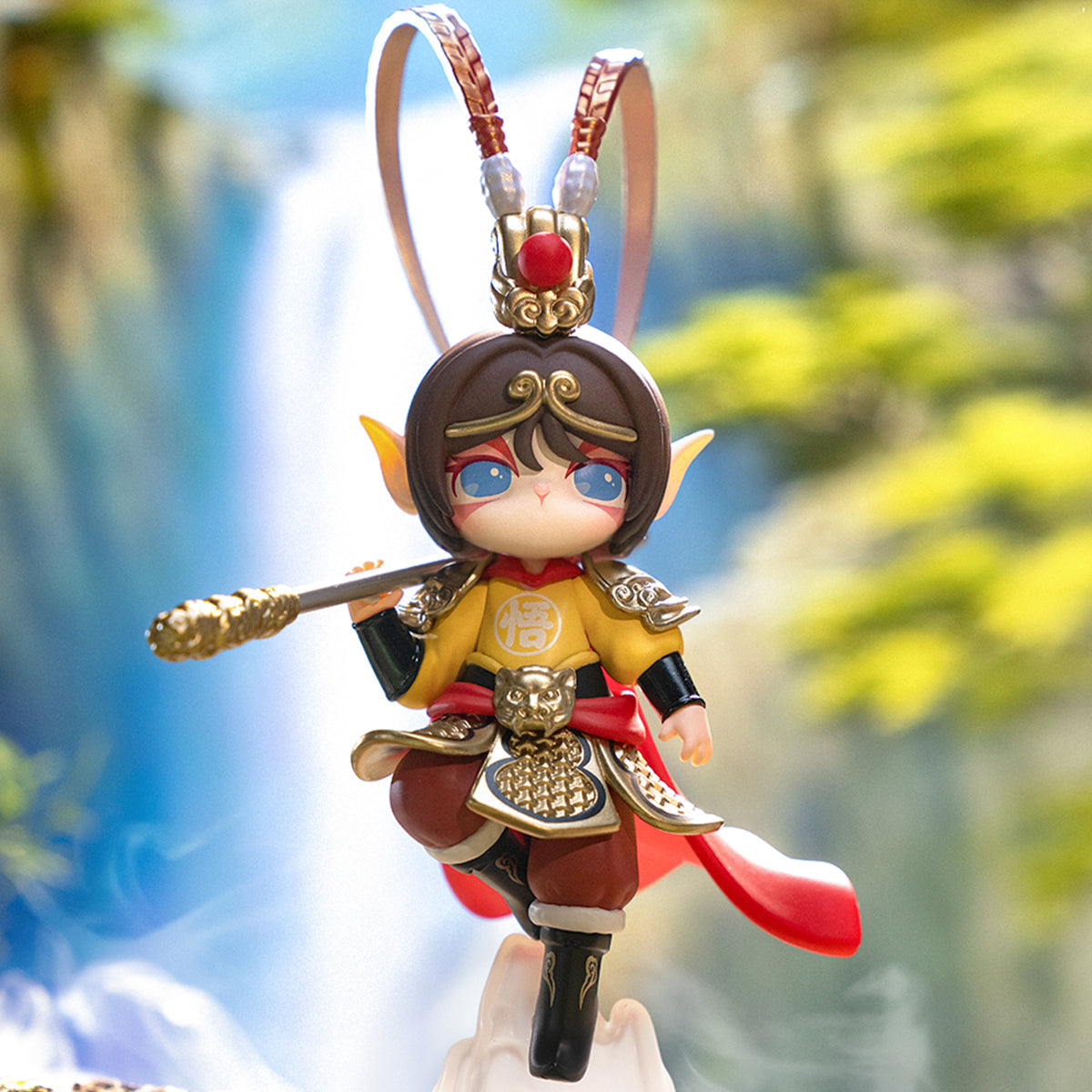 Rolife Suri monkey king charm doll hangs with a staff, red sash, and leafy background.