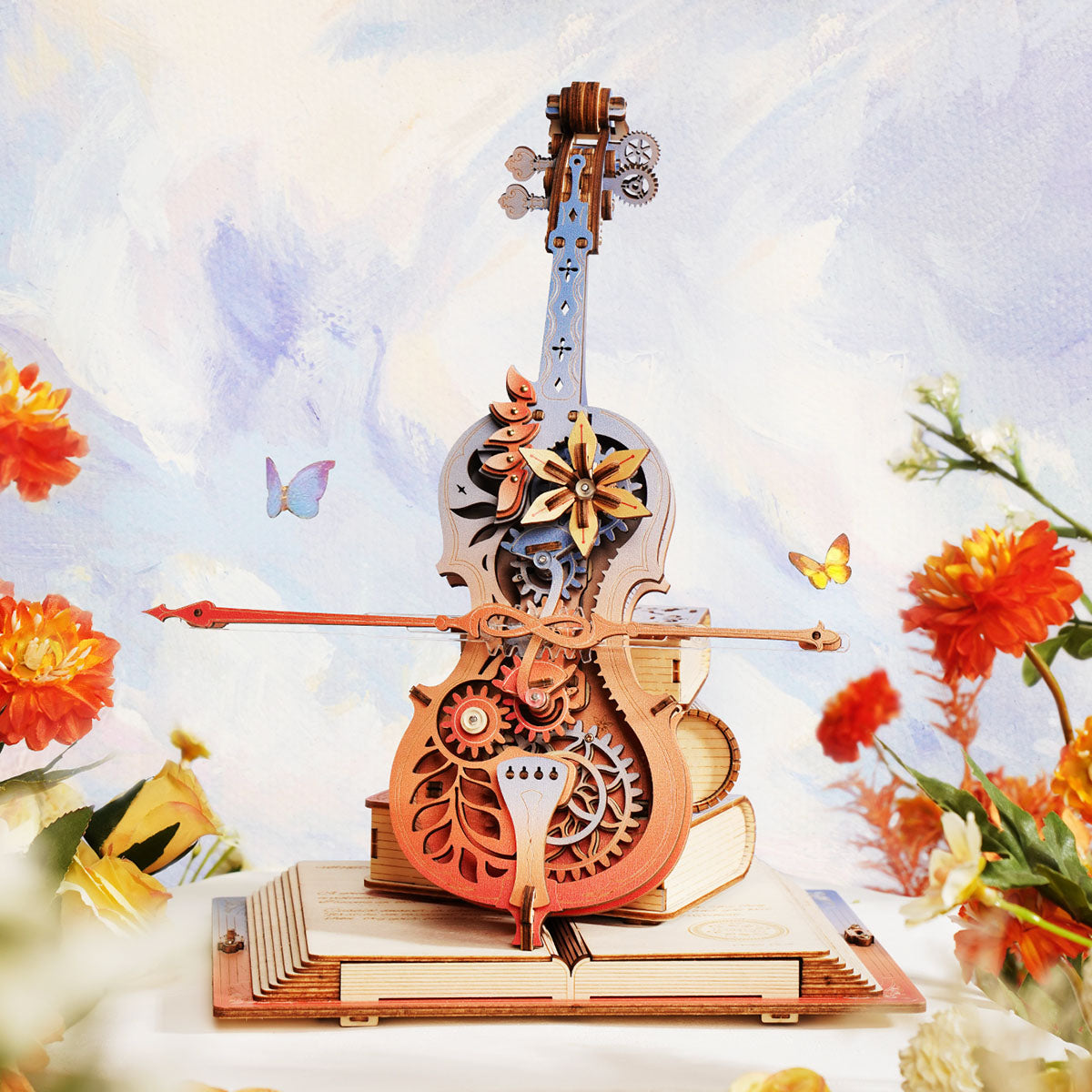 ROKR Symphony of Gorgeous Dreams AMK63M cello music box full view surrounded by orange flowers against a soft watercolor painted garden background