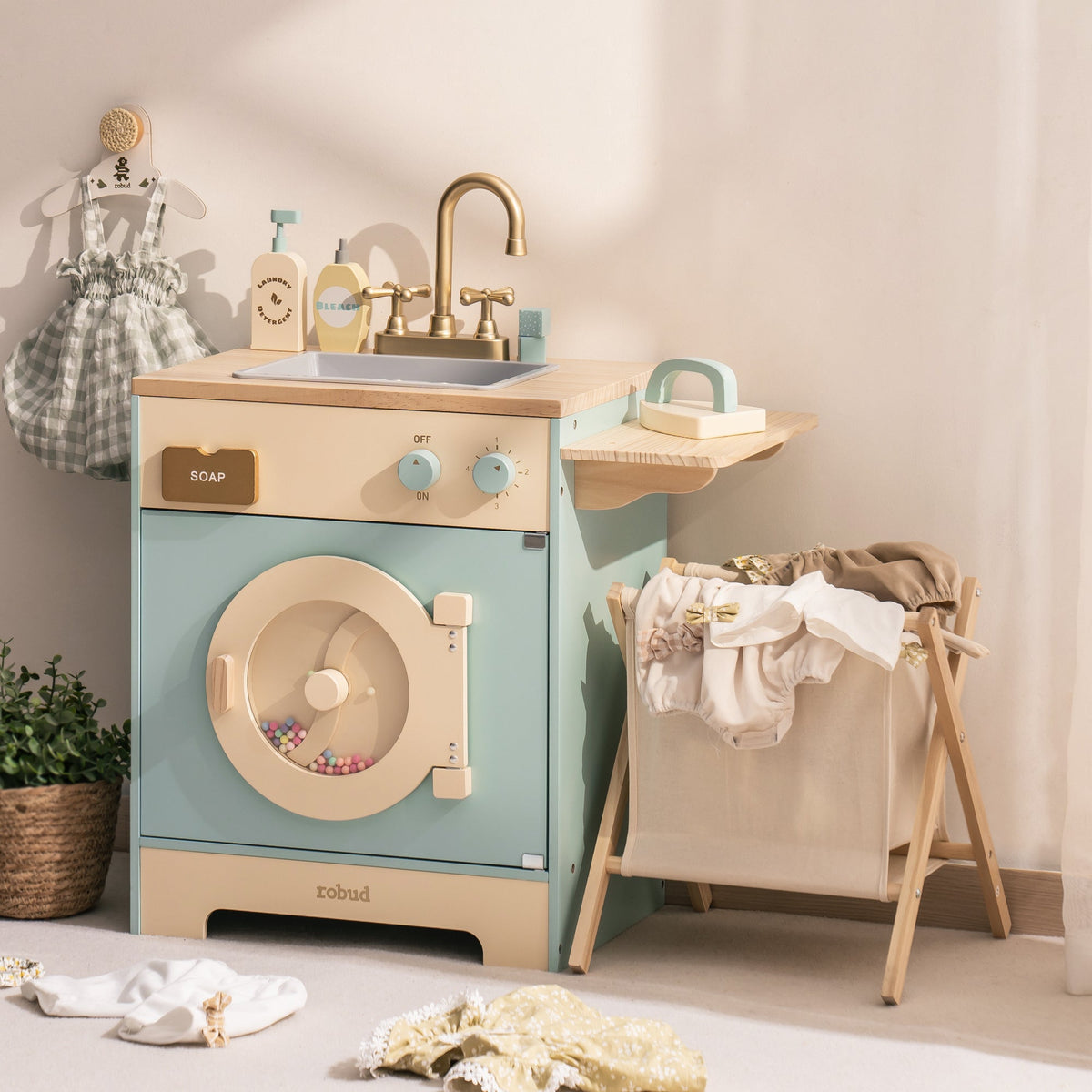 Robud mint blue washing machine toy with front-load drum and laundry basket alongside ironing board
