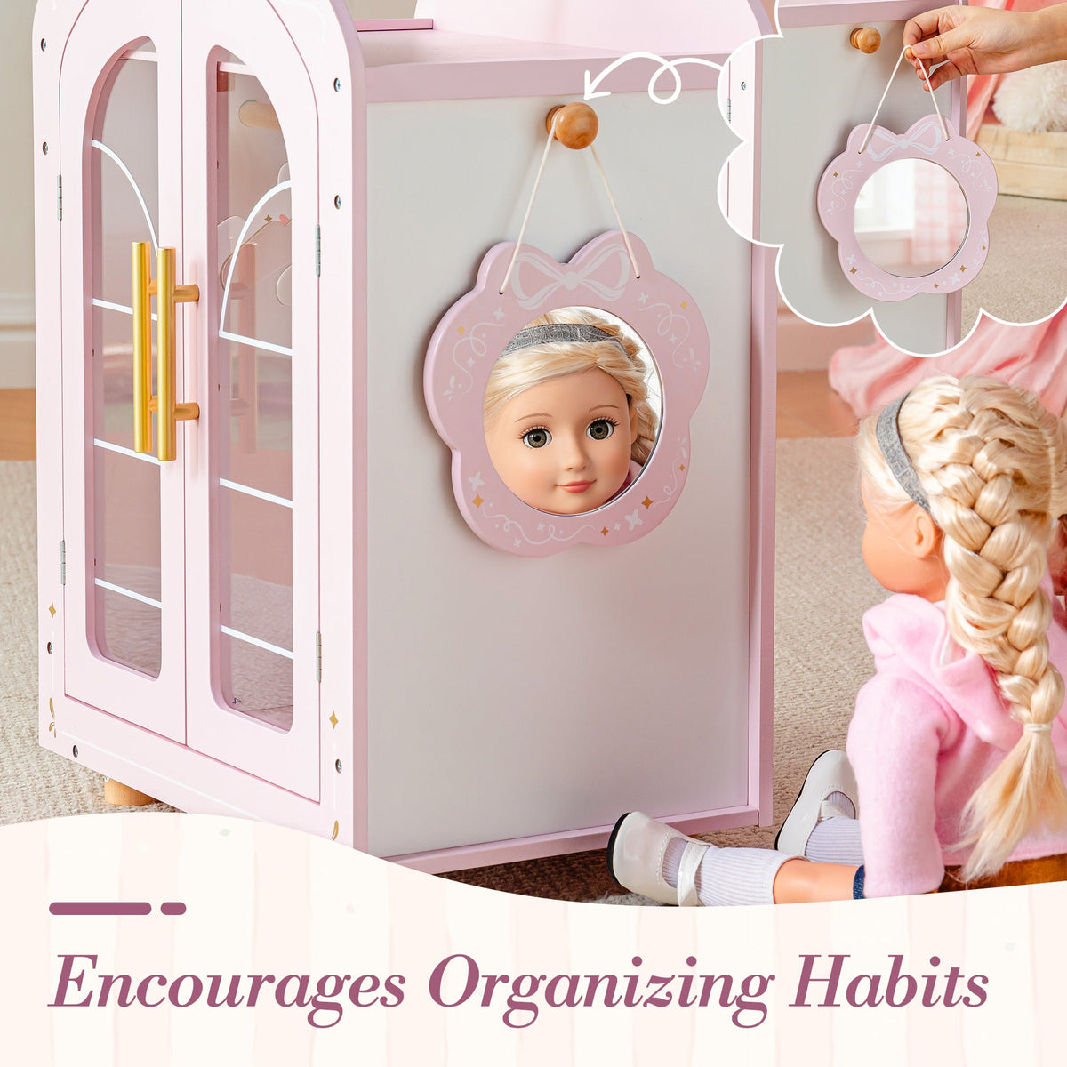 Child places a doll inside the open ROBUD pink arch-door wardrobe beside a round flower mirror on the side panel.