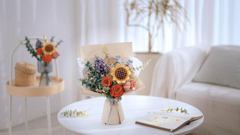 Rowood assembled wooden flower bouquet kit with sunflowers, red camellias, lavender sprigs, pink rose buds, and eucalyptus wrapped in cream paper on a white round table in a bright room