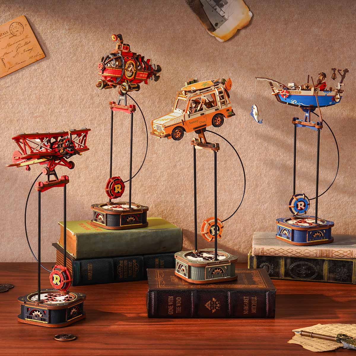 ROKR Road Tripper MCD03 collection lifestyle showing four ROKR Gravity Swing pendulum models including biplane submarine SUV and boat on vintage books