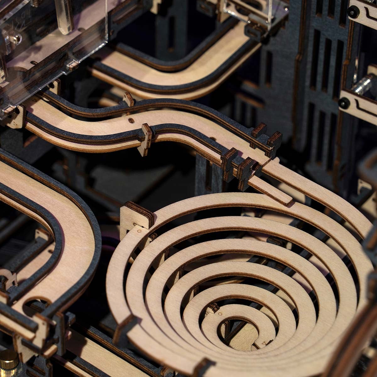 Overhead close-up of ROKR Marble Night City concentric spiral track and curved wooden rail channels in warm honey tones