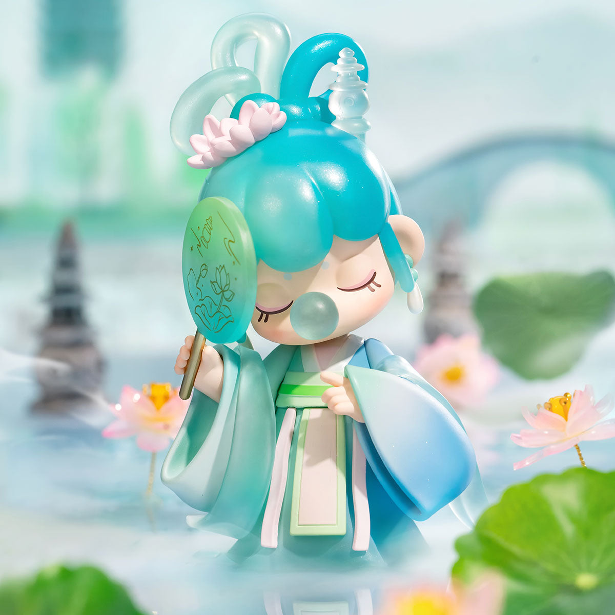 Rolife Nanci Poetic Beauty teal hanfu figure doll beside lotus pond with soft-focus pagoda backdrop