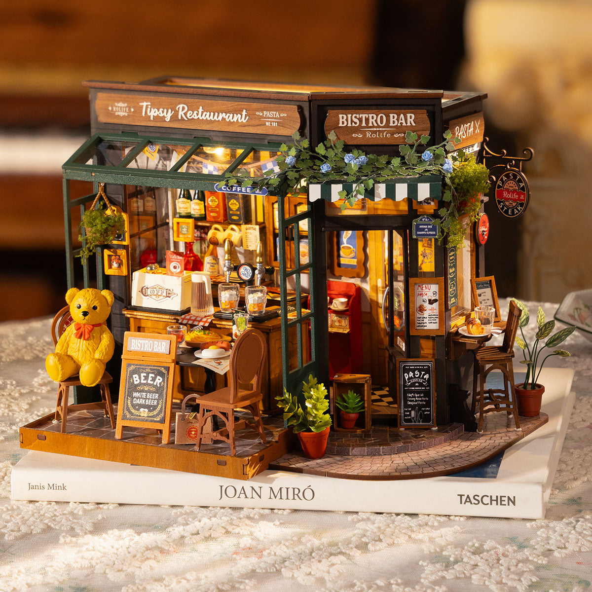 Rolife Tipsy Restaurant DG167 close-up of miniature bear dining at the table with pasta menu, wine glasses and bistro accessories under warm lighting