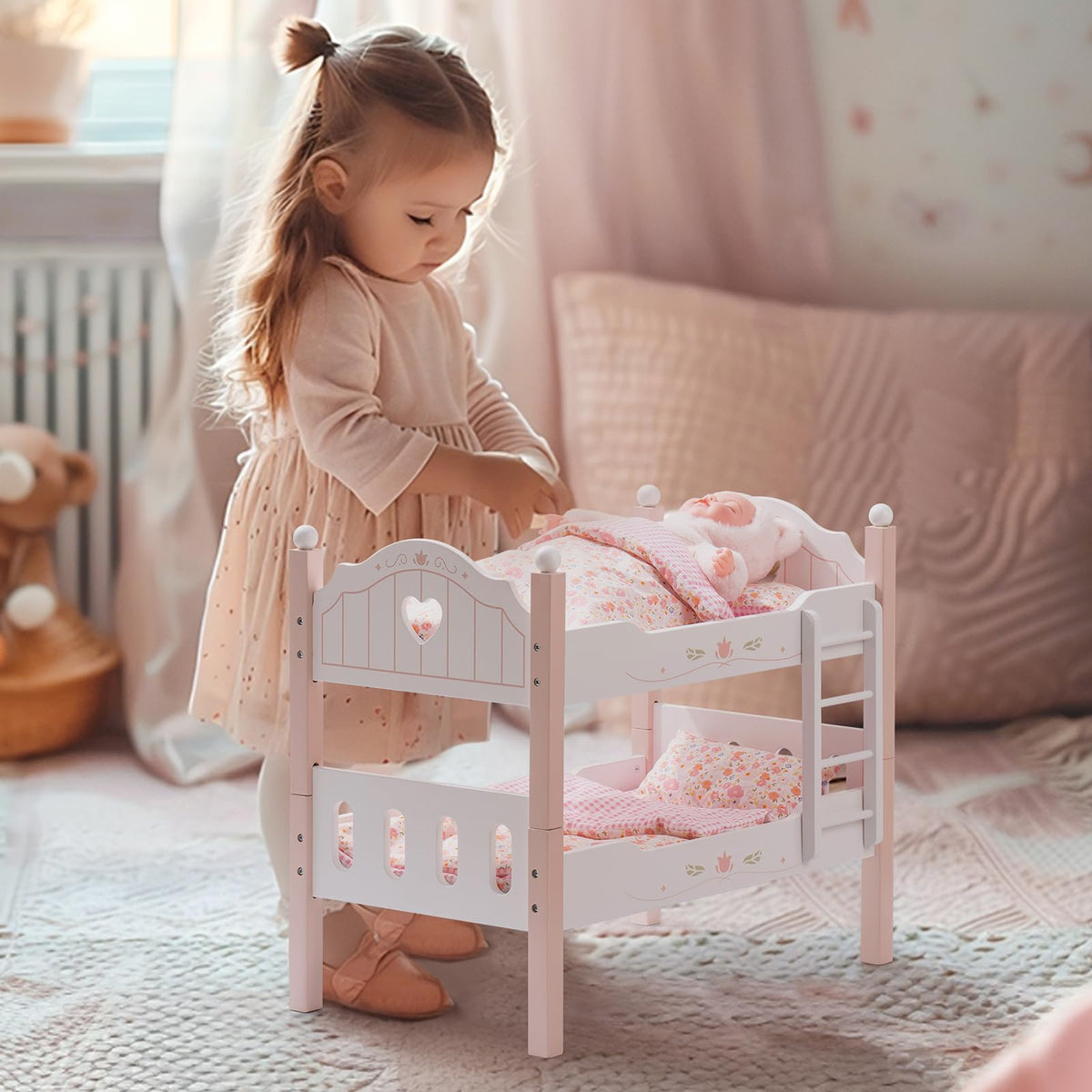 Young girl in a peach dress tucks a doll into the white ROBUD wooden princess bunk bed in a softly lit pastel room.