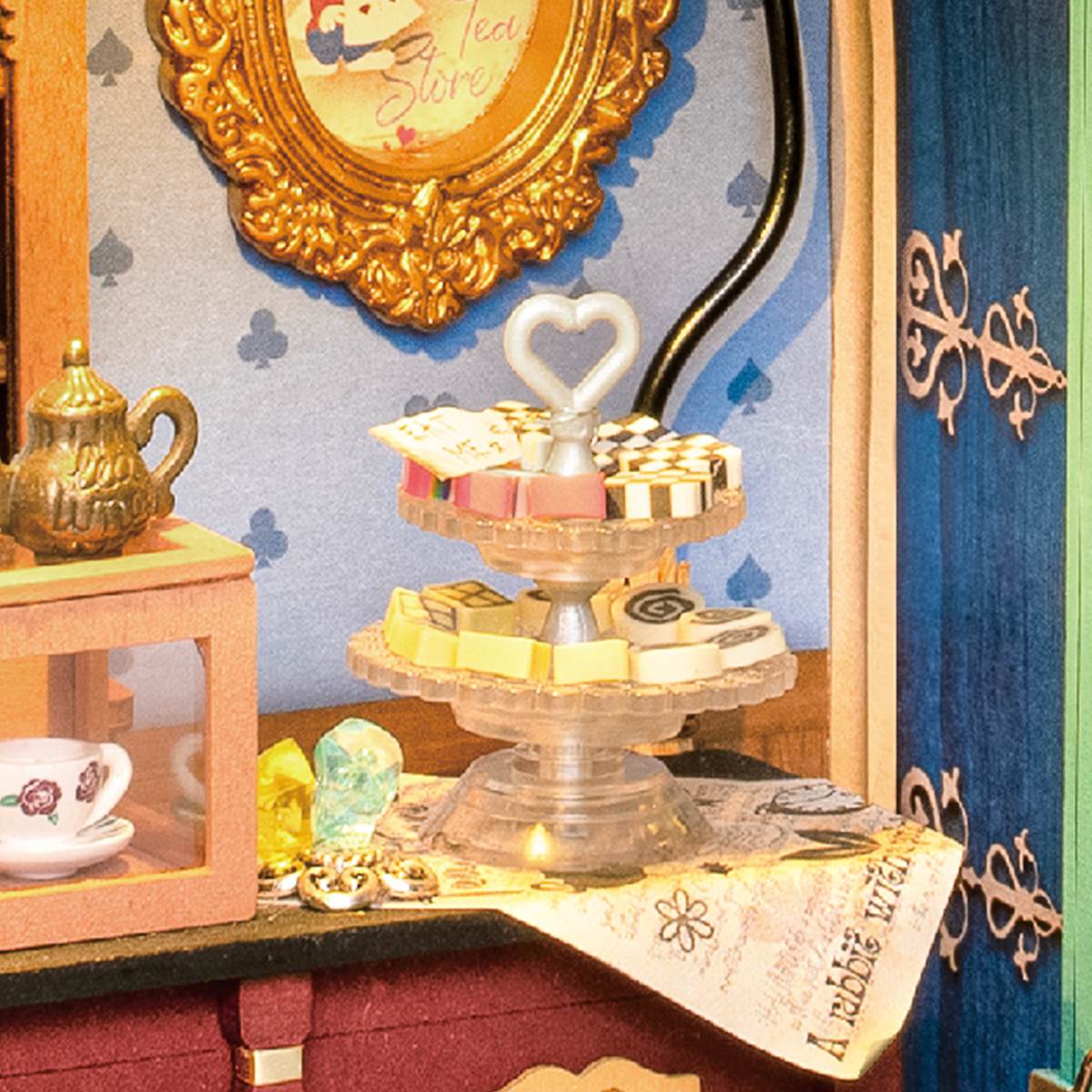 Rolife Alice's Tea Store close-up of a heart-topped tiered dessert stand with macarons beside a golden ornate mirror