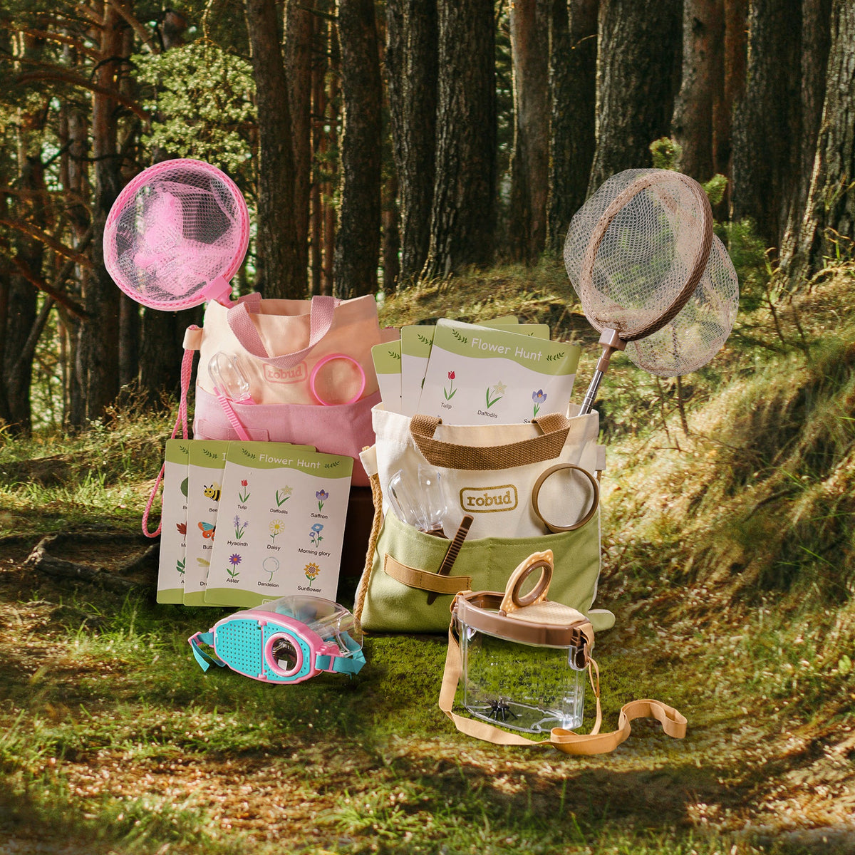 ROBUD pink outdoor explorer kit laid out in forest on moss showing all tools including nets, containers, binoculars, and pink tote bag