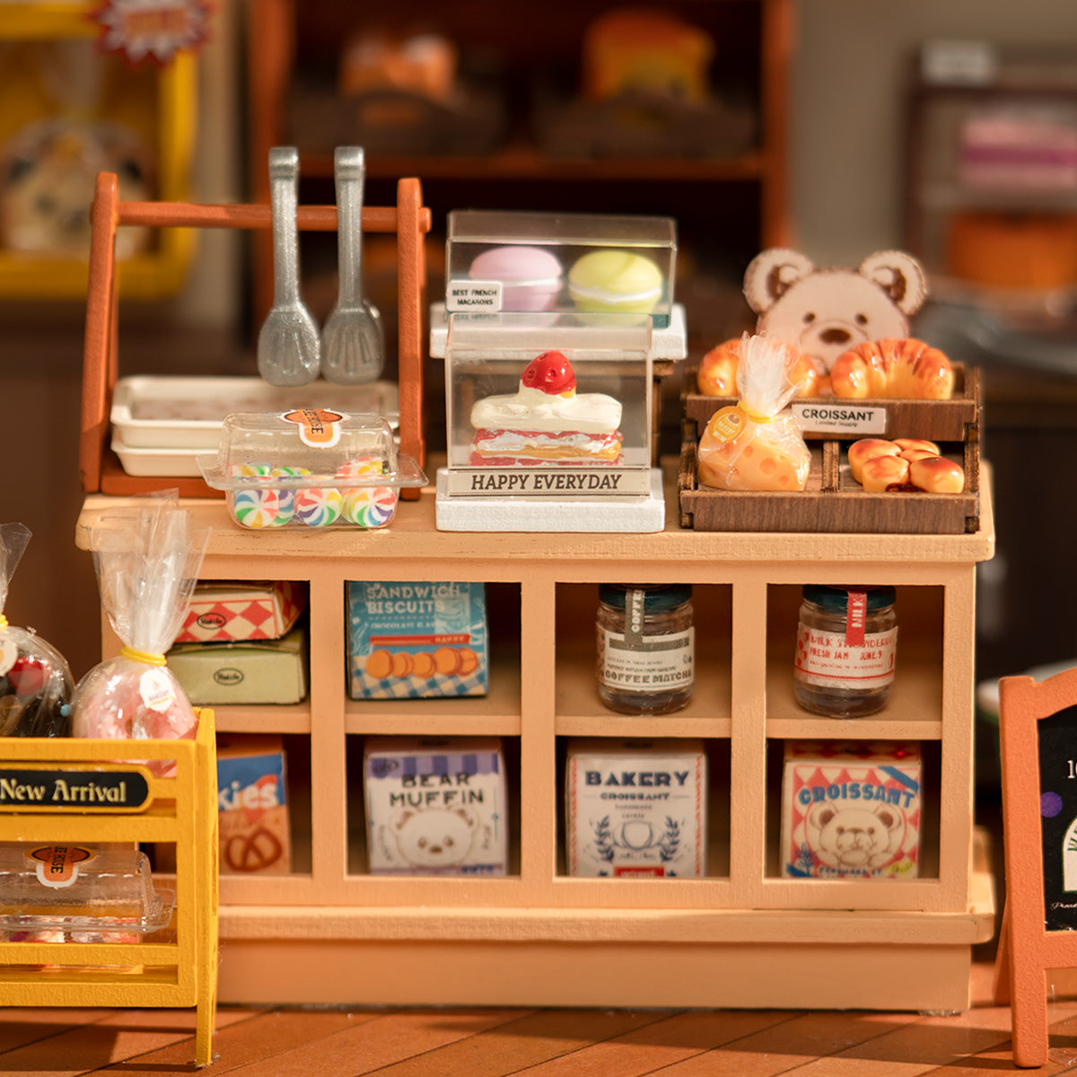 Rolife Beckas Baking House bakery counter close-up with cakes, pastries, bear figure and labeled shelf jars