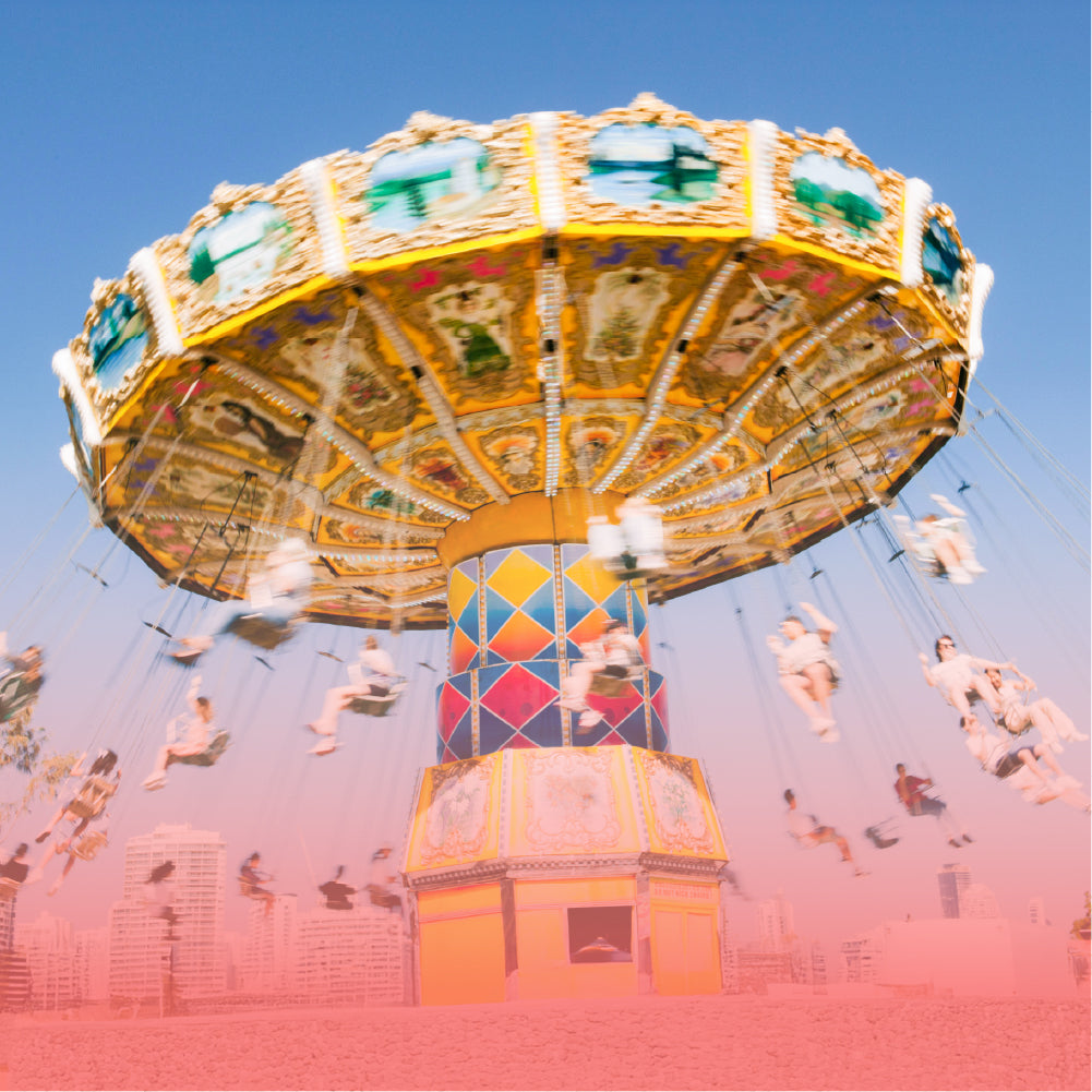 Real fairground chain swing carousel spinning against a blue sky with a soft pink-red gradient overlay.