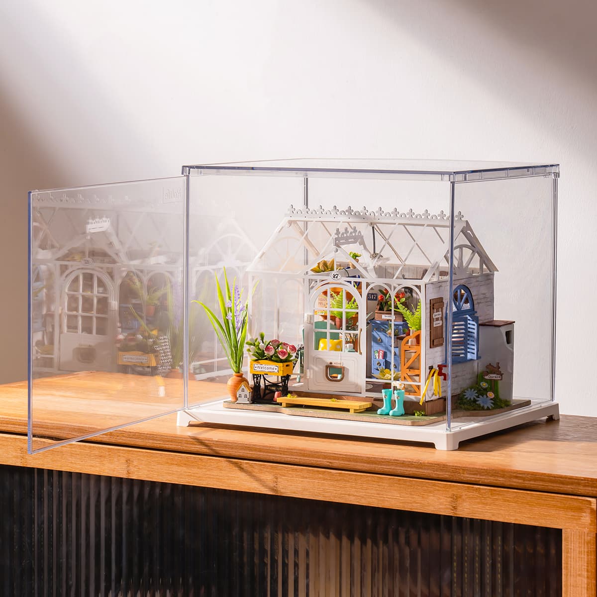 Rolife Dreamy Garden House in a clear display box is shown at an angle on a tabletop.