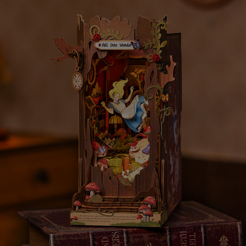 Rolife Alice in Wonderland Fall Into Wonder DIY book nook glowing with warm amber light and Alice falling figure surrounded by mushrooms and roses