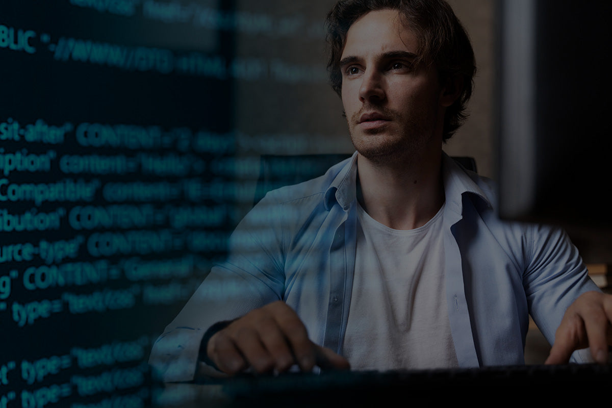 Robotime Online Gifts for Tech Enthusiasts, man at keyboard with HTML code glowing on monitor in dark studio
