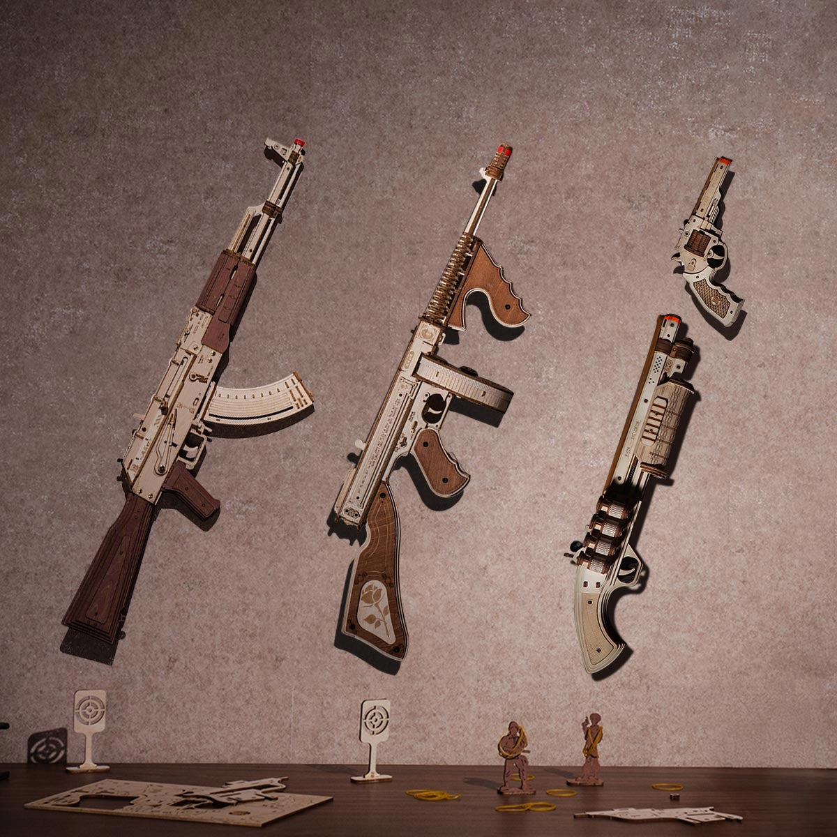 ROKR AK-47 Assault Rifle Toy Gun LQ901 3D wooden puzzle, three completed wooden gun replicas mounted on a gray wall, AK-47, Thompson and shotgun, with target stand accessories below