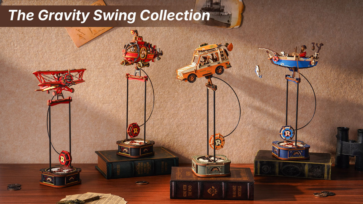 ROKR Gravity Swing collection banner showing four pendulum toys including biplane, steampunk airship, road-trip SUV, and fishing boat on stacked books