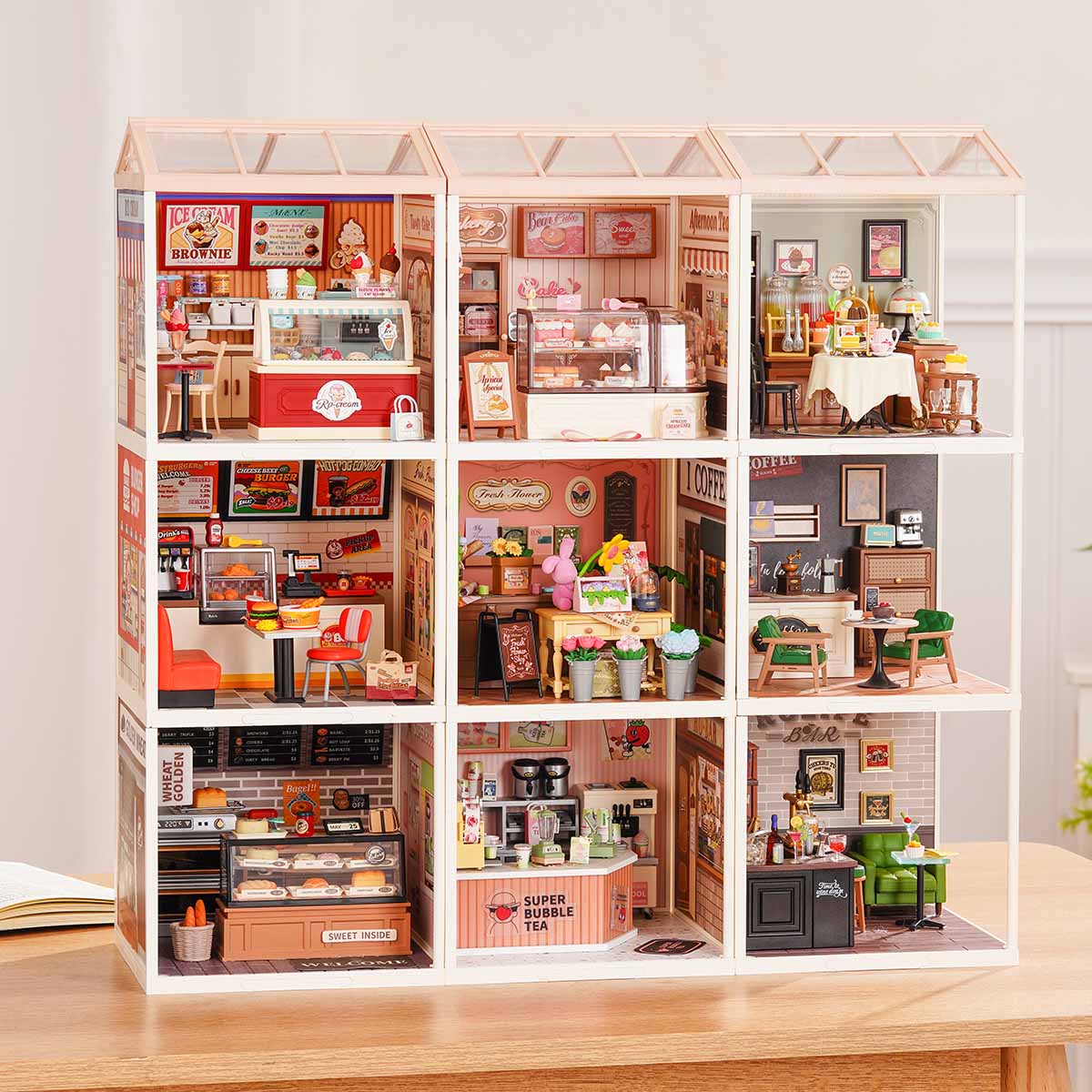 Rolife Super Creator Series 9-in-1 Nine Grid miniature town building set showing ice cream shop, burger diner, bar, and bubble tea rooms in a white grid frame.