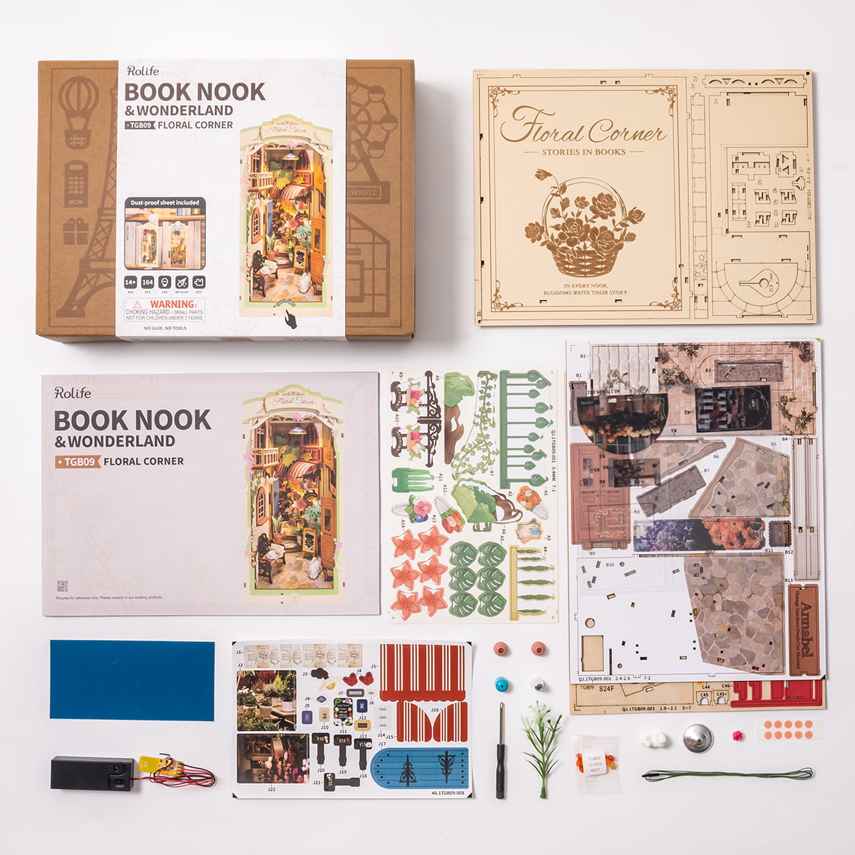 Rolife Floral Corner TGB09 Book Nook kit contents laid out flat showing instruction book wooden sheets sticker sheets and battery pack components