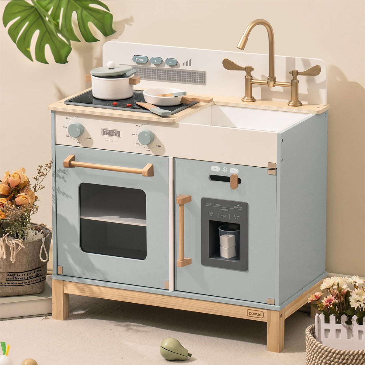 ROBUD blue-grey play kitchen with plants on countertop, gold faucet and modern Boho room setting.