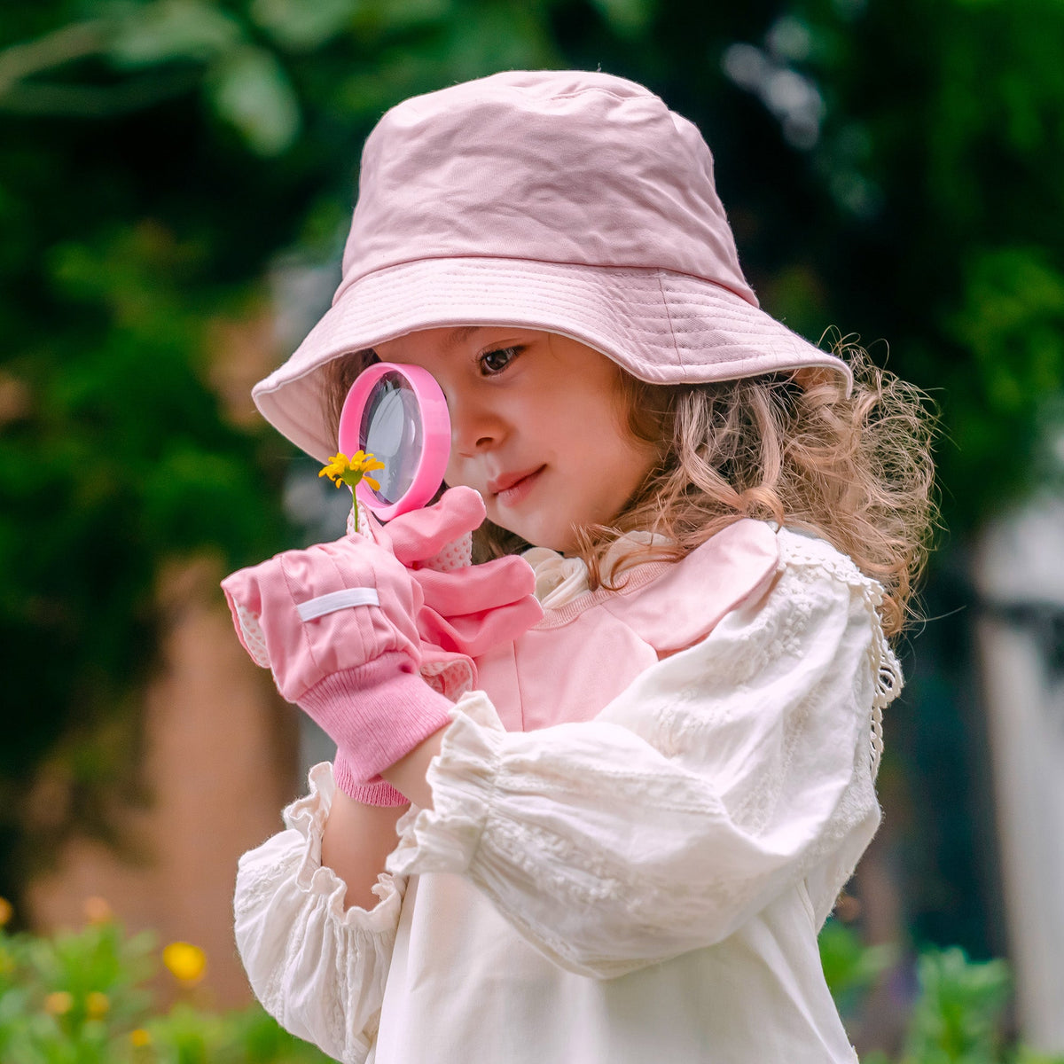 ROBUD Kids Gardening Set pink edition all items laid out on a floral-print surface including tote bag, apron, hat, tools and potting cups