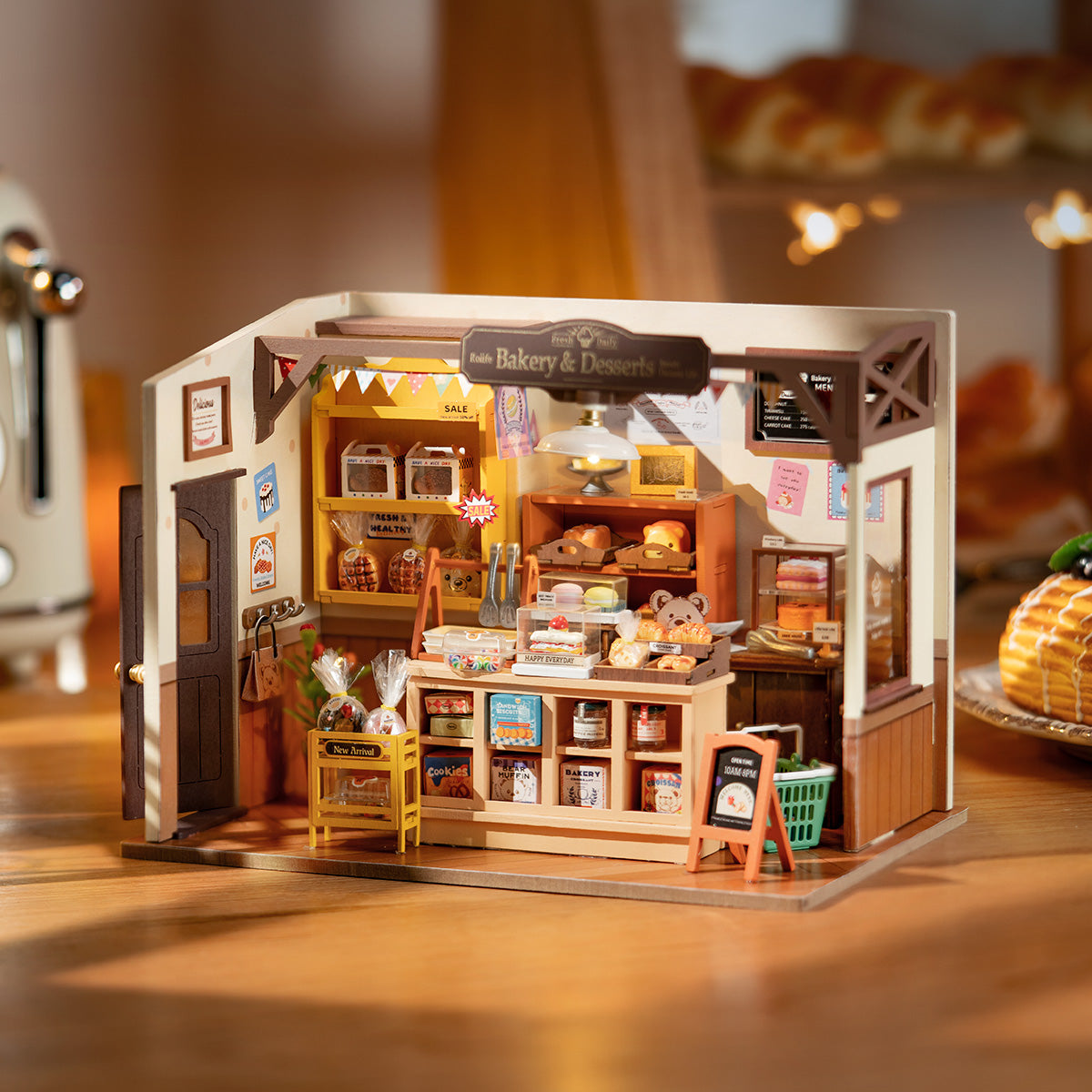 Rolife Beckas Baking House miniature with warm bakery interior, counter display, brick walls and hanging string lights