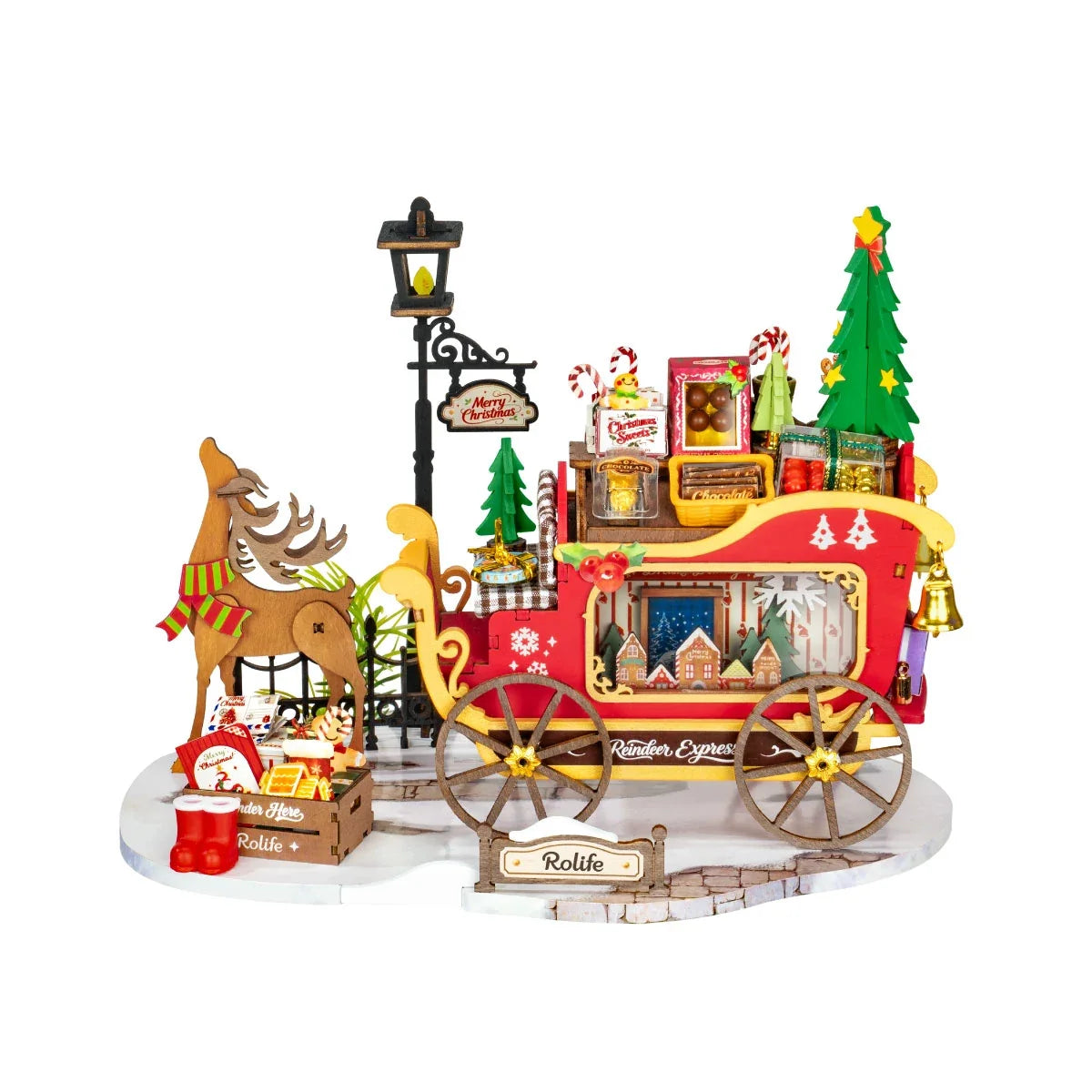 Rolife-Miniatur mit Holzrentier und rotem Schlitten auf weißer Basis, mit Laternenpfahl, Weihnachtsbaum, Geschenken, Süßigkeiten und Rolife-Schild.