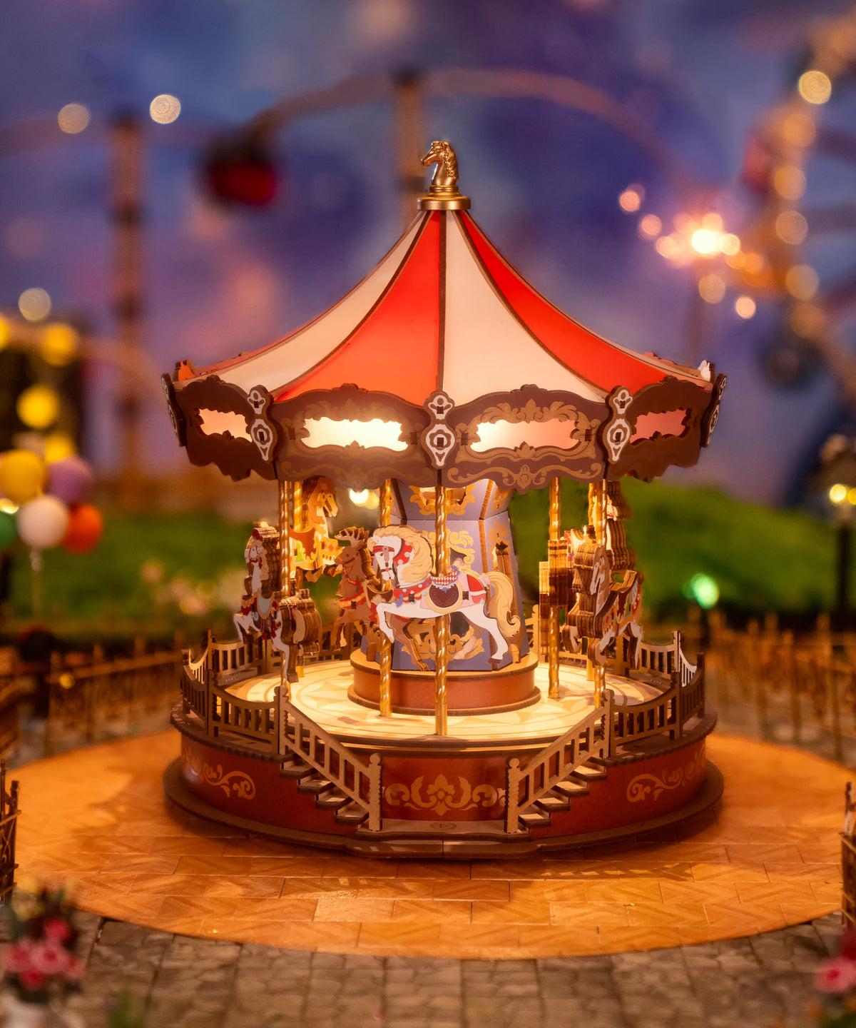ROKR illuminated carousel wooden 3D puzzle glowing with warm lights and decorative horses displayed in a fairground scene at dusk.