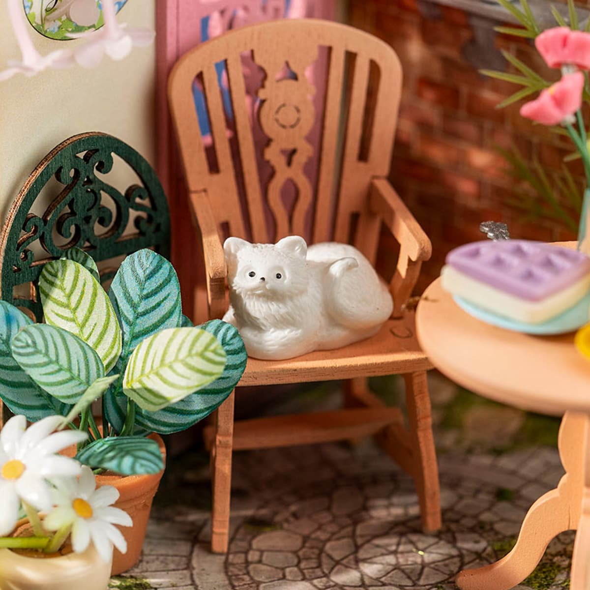 Rolife garden miniature close-up with white cat resting on a wooden chair surrounded by green tropical leaves