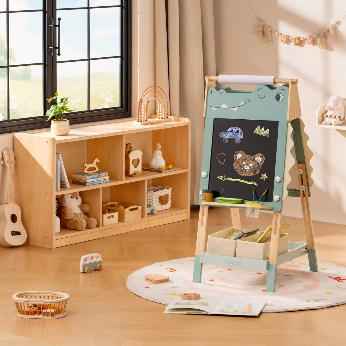 ROBUD dinosaur double-sided easel with chalkboard turned outward displayed in a sunlit playroom alongside a storage unit.