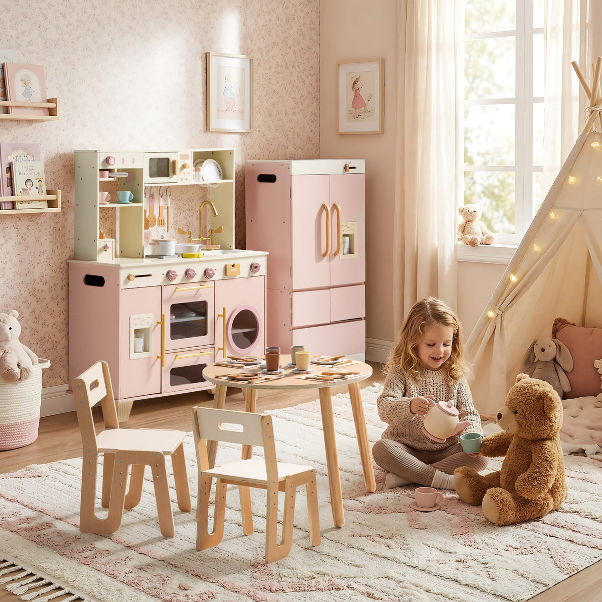 Little girl hugging a teddy bear at a natural wood table surrounded by the ROBUD Glowwood pink kitchen and fridge set.