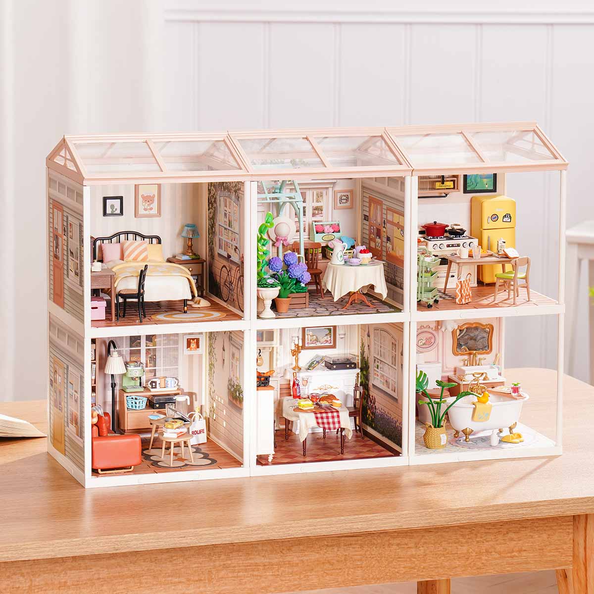 Rolife Super Creator Series 6-in-1 Six Grid miniature with six shop rooms including Super Bubble Tea, Wheat Golden Bakery, Burger Shop, Rolife Bar, bookstore, and afternoon tea on a desk.