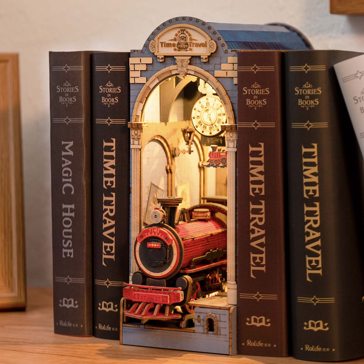 Rolife Time Travel DIY book nook displayed between Magic House and Time Travel hardcover books on shelf