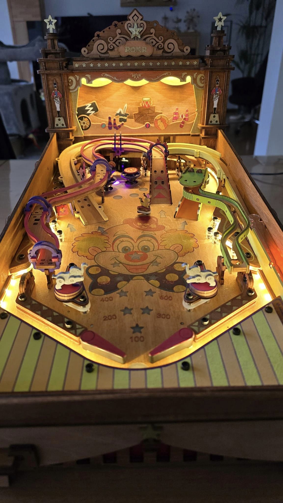 Robotime illuminated pinball table shows a gold playfield and warm lights.