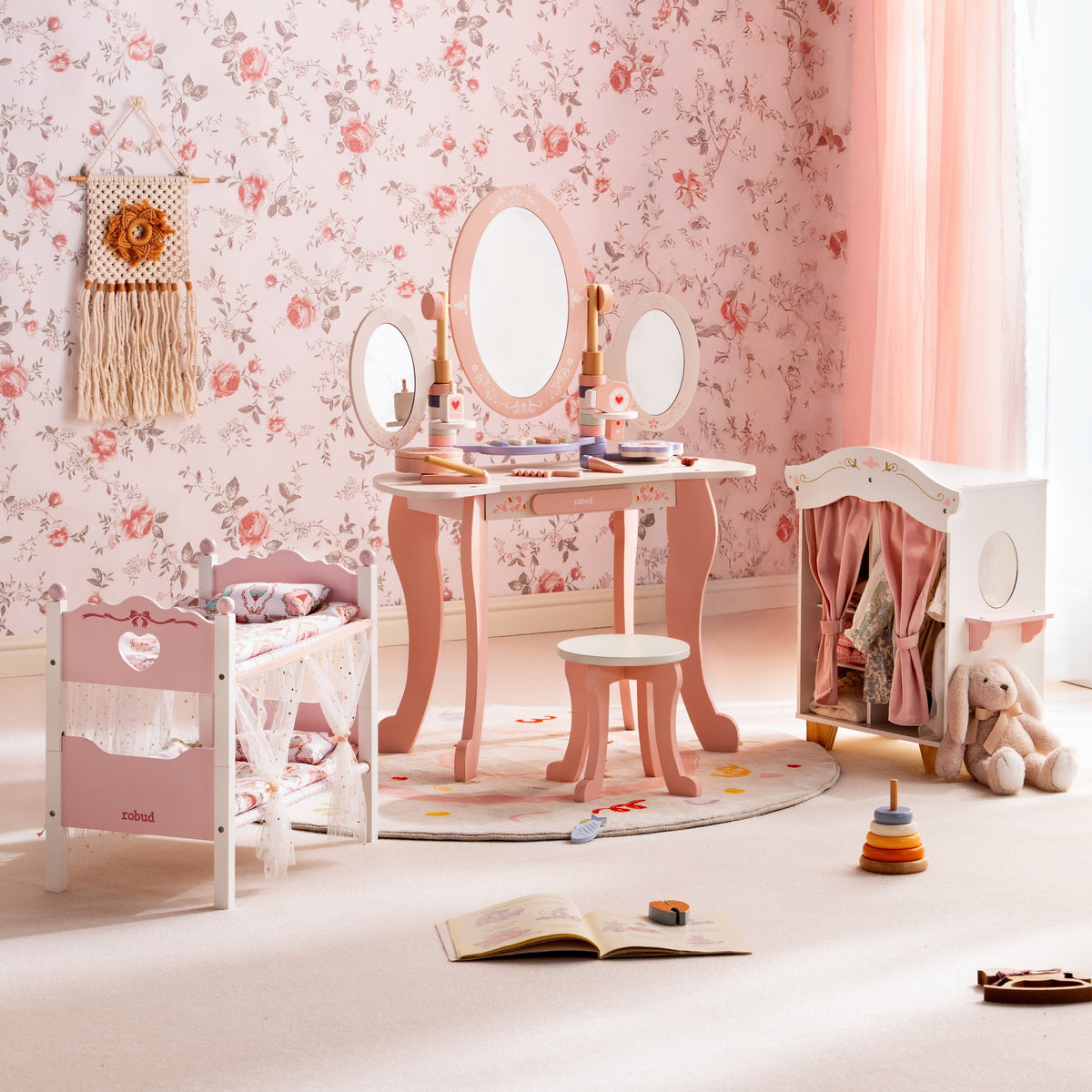 ROBUD pink princess play room featuring a triple vanity mirror doll cradle and fabric wardrobe on a floral backdrop.