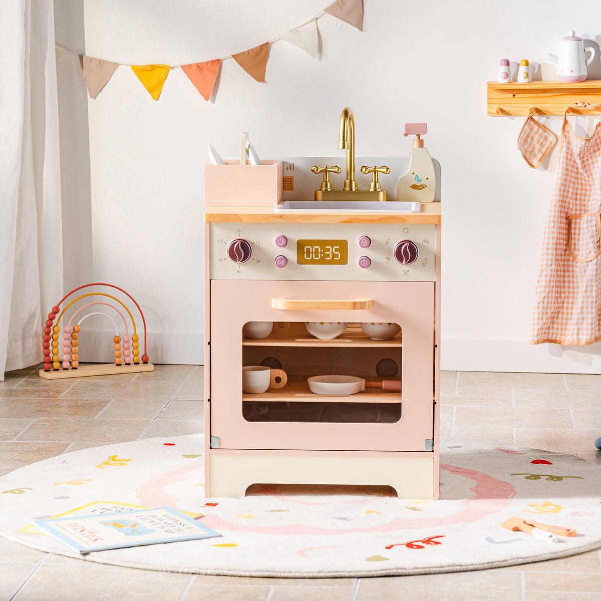 ROBUD Pink Wooden Kitchen PlaySet oven and stove unit in a colorful playroom with pennant flags on wall