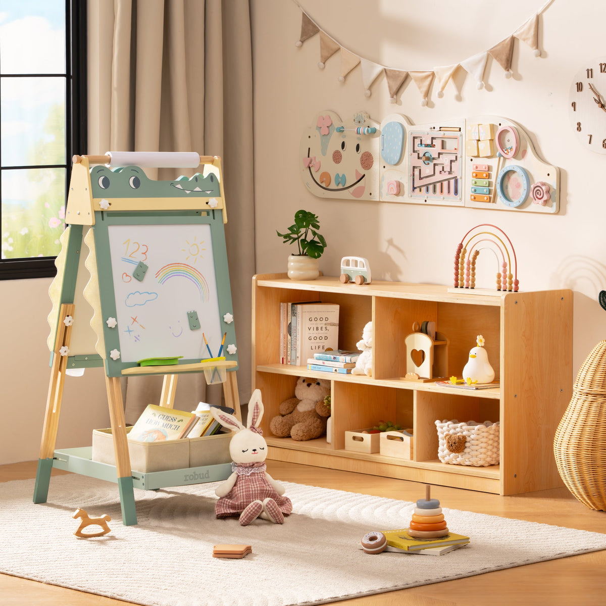 ROBUD double-sided easel beside wooden bookshelf showing both whiteboard and chalkboard faces in a light boho setting.