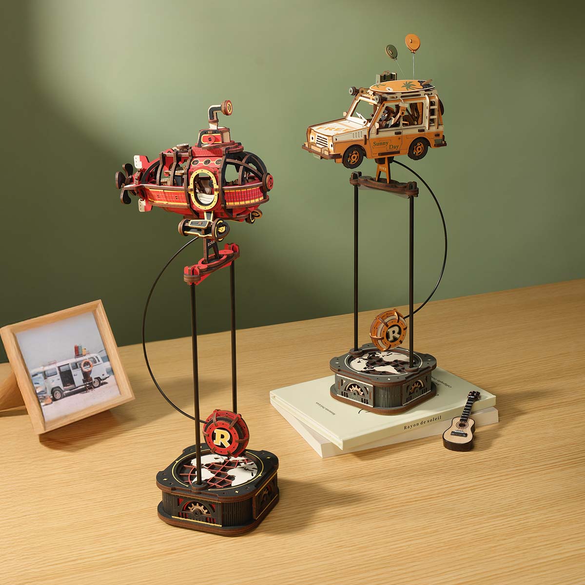 ROKR Road Tripper Gravity Swing MCD03 lifestyle scene with orange SUV on pendulum stand alongside books, a guitar ornament, and warm desk lamp light