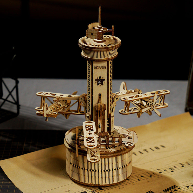 ROKR Airplane Control Tower music box with three wooden biplanes circling tall laser-cut tower on dark background