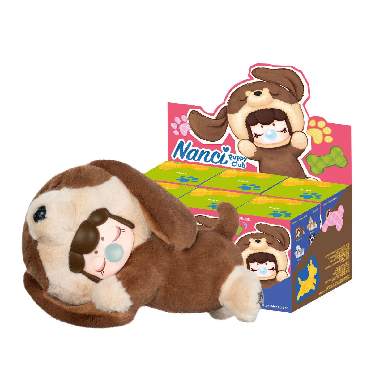 Braune Plüschfigur mit Welpenkapuze liegt mit geschlossenen Augen und blauer Blase auf der Seite, neben einer Display-Box des Rolife Nanci Puppy Club.