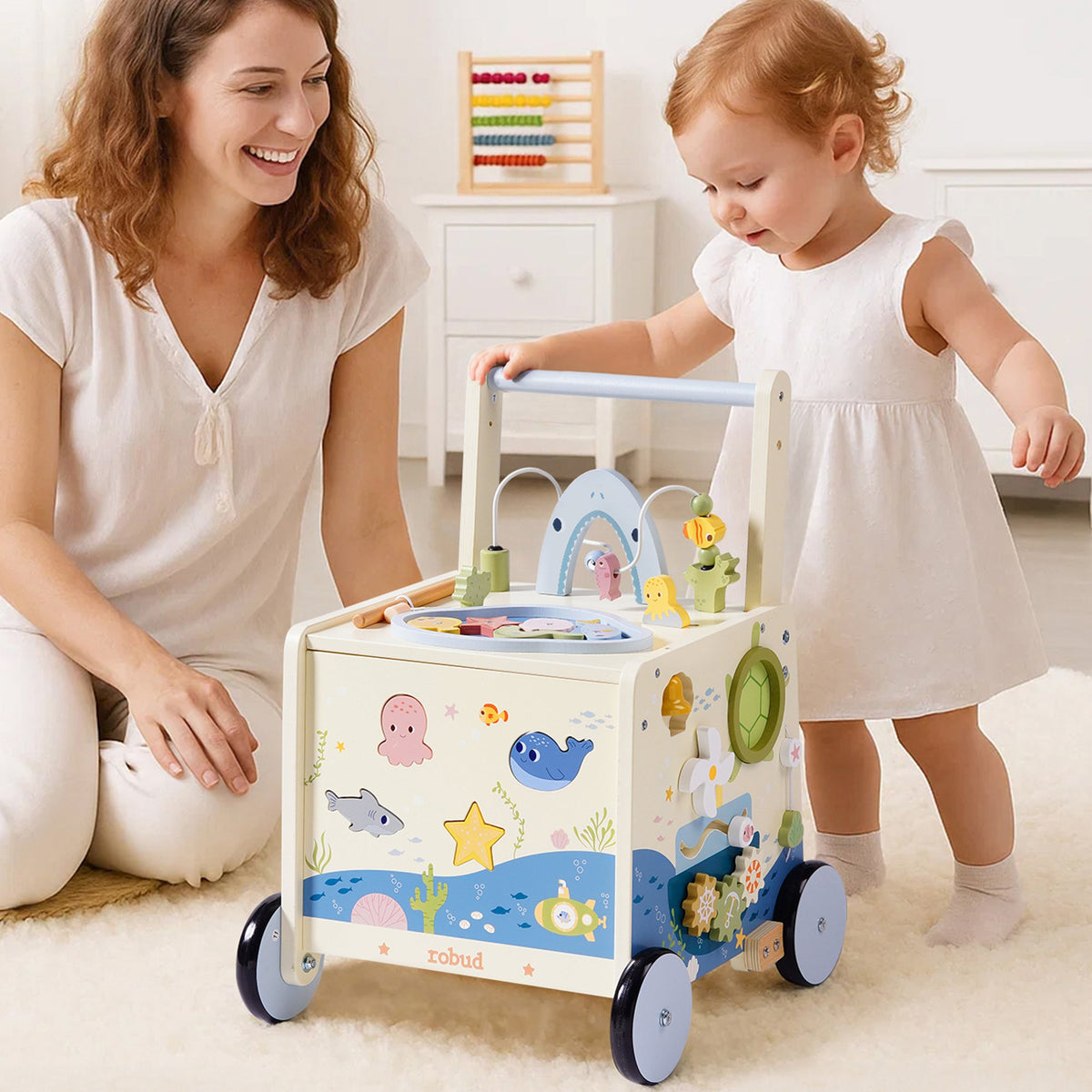 ROBUD Wooden Baby Push Walker Underwater World with mother and baby girl exploring the white wooden activity walker with ocean illustrations