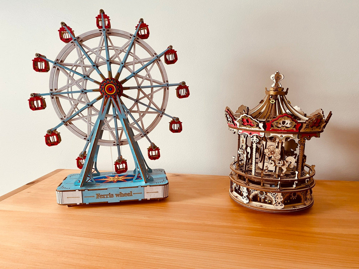 Robotime Ferris wheel and carousel models stand together on a tabletop.