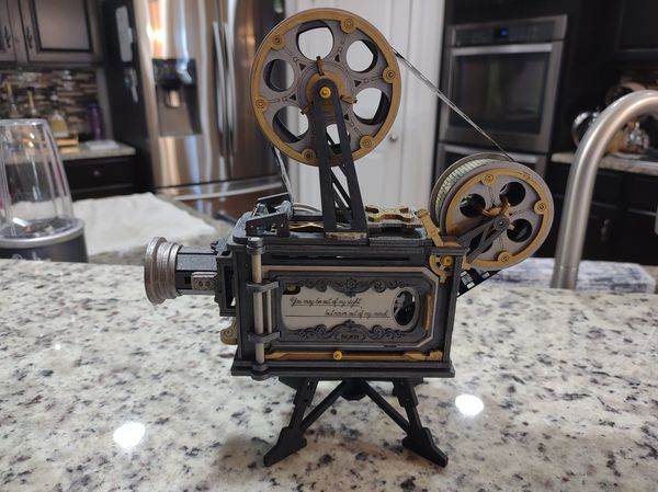 Robotime vintage film projector model has twin reels and a black metal body.