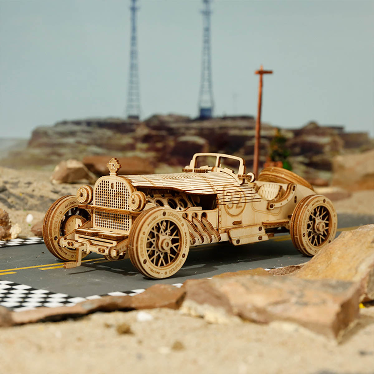 ROKR Grand Prix 3D wooden puzzle race car front view with large spoked wheels on desert racetrack scene