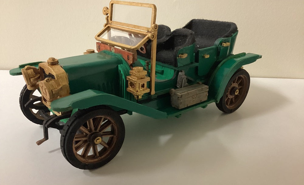 Robotime green vintage car model has black wheels and tan seats on a white surface.