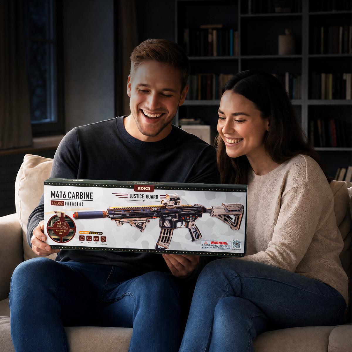 Couple smiling on a sofa while holding the rifle model's retail box together in a living room