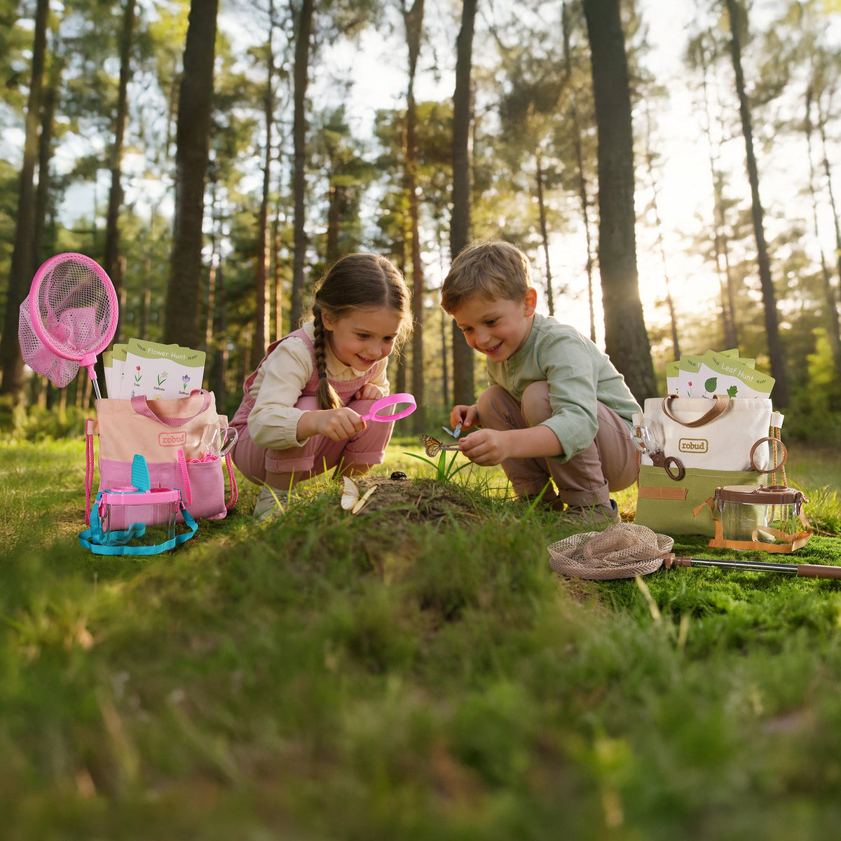 ROBUD dual explorer kits pink and green laid out in forest setting on moss showing nets, bags, containers, and guide cards
